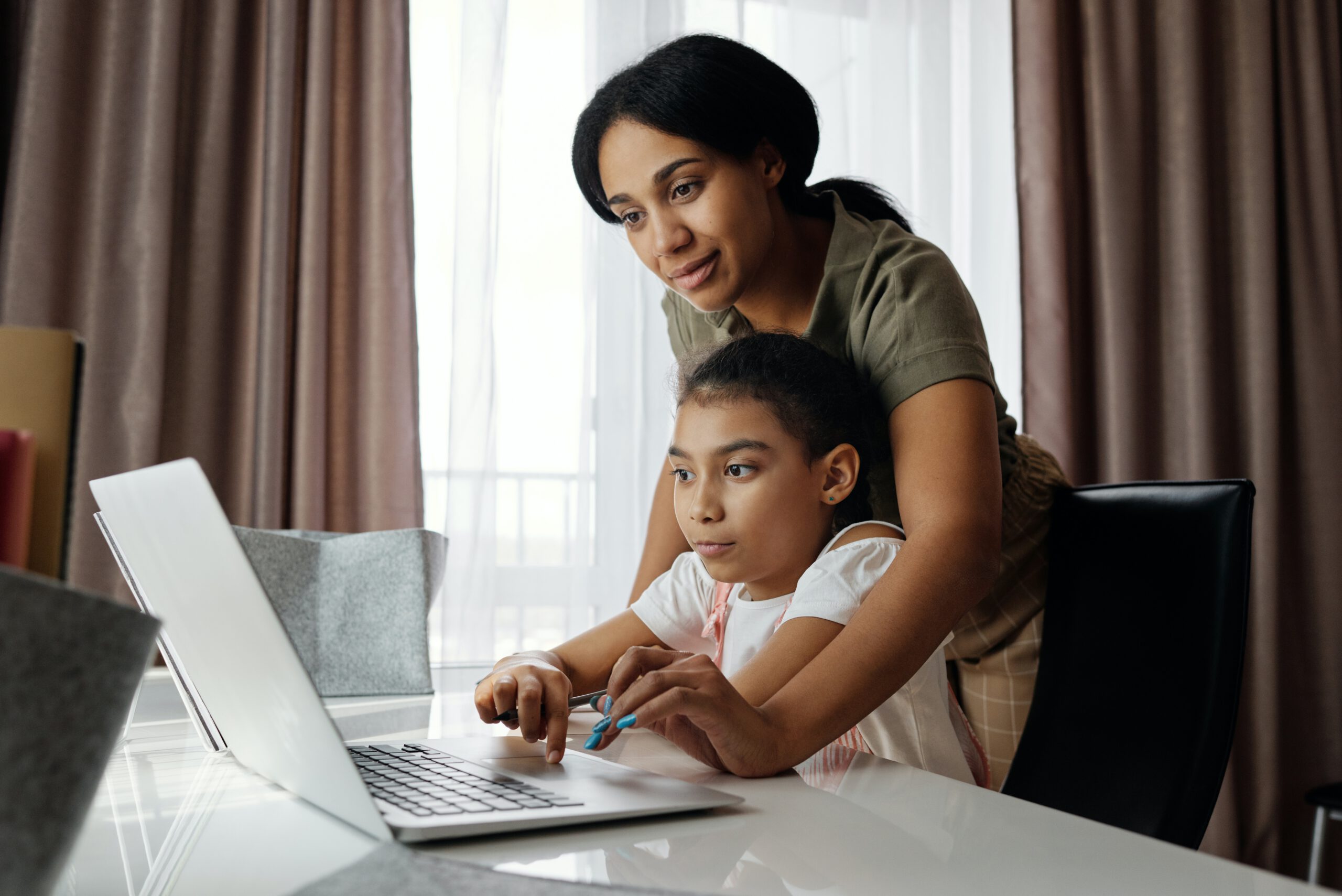 Mama z córką przed laptopem podczas nauczania domowego w domu